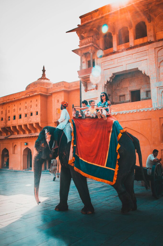 Tourists enjoying an elephant ride at Amber Fort in Jaipur, capturing vibrant Indian architecture and culture.